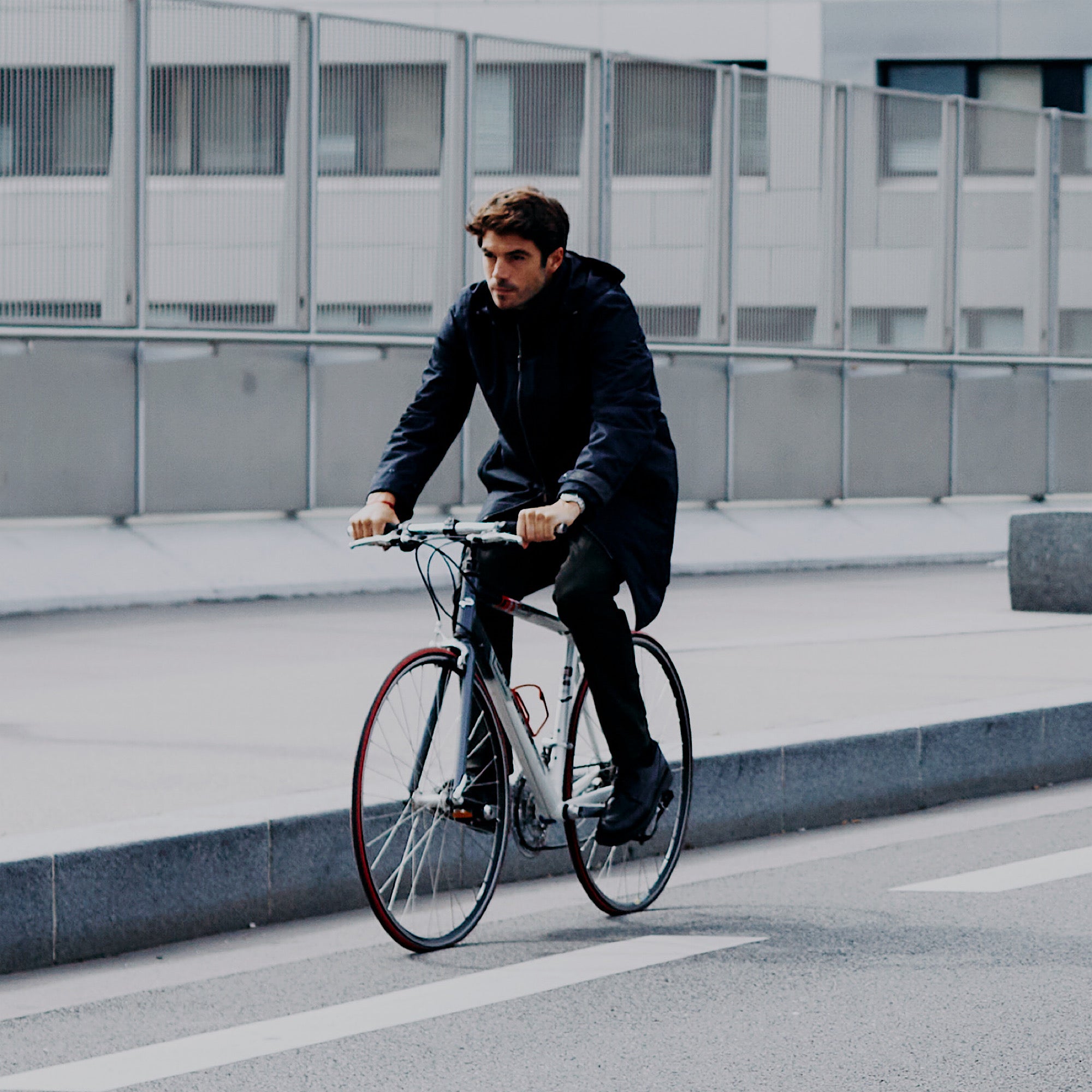 VEST PARIS — veste moto urbaine technique, protection discrète, pilote tenant un casque, scène de ville contemporaine.