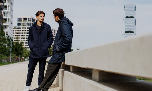 Deux hommes portant des vestes techniques élégantes VEST PARIS dans un environnement urbain moderne